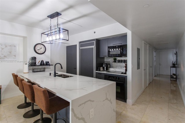 kitchen featuring light stone countertops, sink, hanging light fixtures, kitchen peninsula, and black appliances