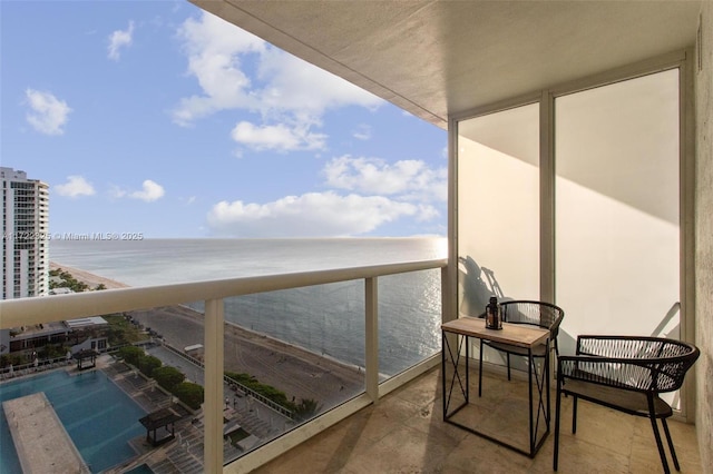 balcony with a water view and a beach view