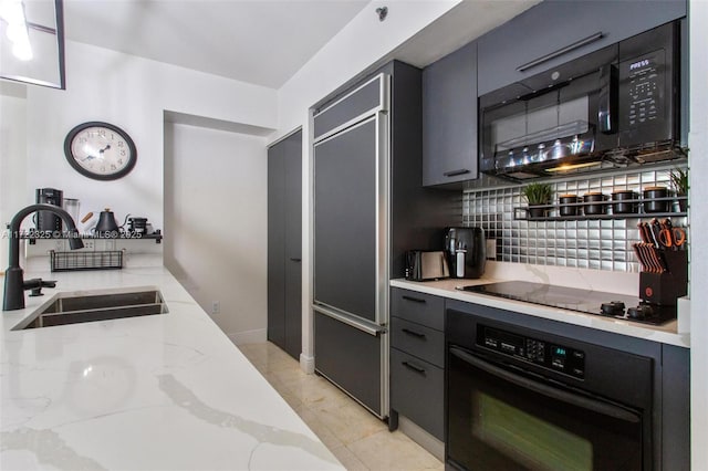 kitchen with decorative backsplash, light stone counters, sink, black appliances, and light tile patterned floors