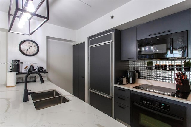 kitchen featuring black appliances, sink, hanging light fixtures, decorative backsplash, and light stone countertops