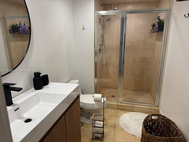 bathroom with tile patterned flooring, vanity, toilet, and a shower with shower door