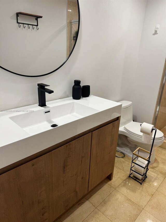 bathroom featuring tile patterned floors, vanity, and toilet