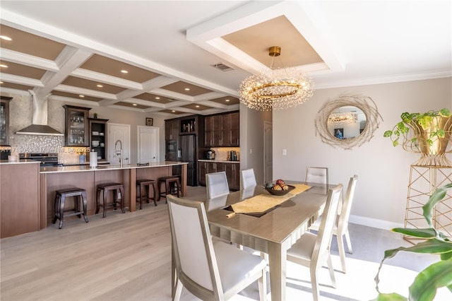 dining area with coffered ceiling, light hardwood / wood-style floors, ornamental molding, a notable chandelier, and beam ceiling