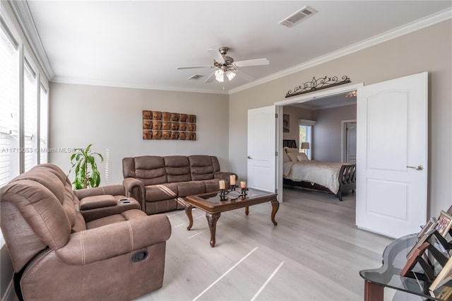 living room featuring ceiling fan, light hardwood / wood-style flooring, crown molding, and plenty of natural light