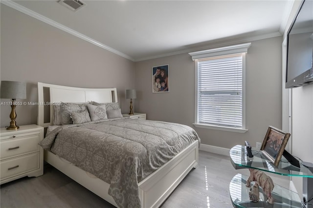 bedroom featuring ornamental molding and light wood-type flooring