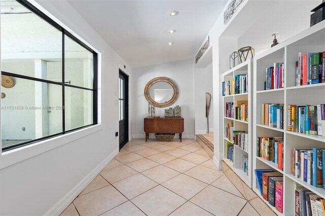 hallway with plenty of natural light and light tile patterned floors