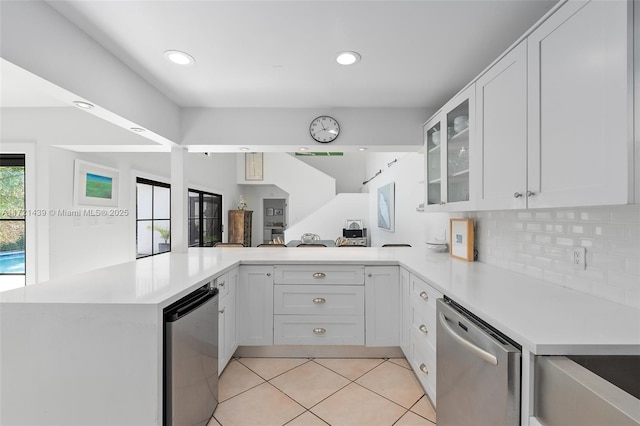 kitchen with tasteful backsplash, white cabinetry, light tile patterned flooring, and kitchen peninsula