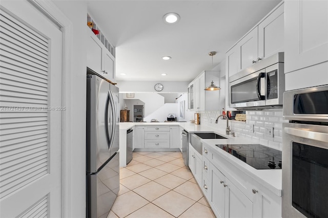 kitchen featuring white cabinetry, stainless steel appliances, and hanging light fixtures