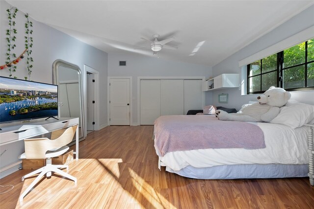 bedroom featuring lofted ceiling, hardwood / wood-style flooring, a closet, and ceiling fan