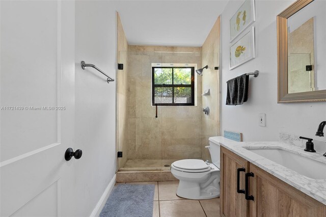 bathroom featuring walk in shower, vanity, tile patterned floors, and toilet