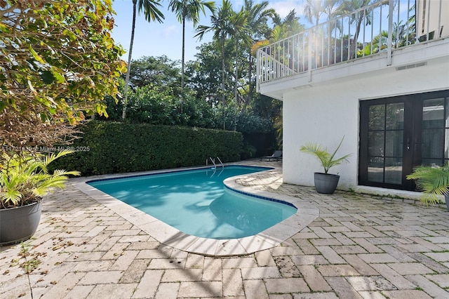 view of swimming pool with a patio and french doors