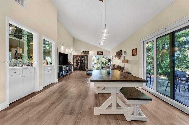 dining room featuring lofted ceiling and light hardwood / wood-style floors