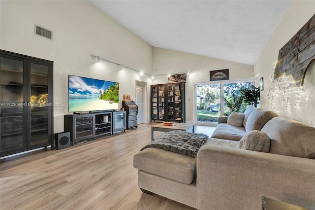 living room with high vaulted ceiling and wood-type flooring