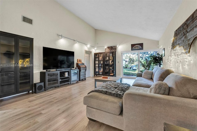 living room featuring high vaulted ceiling and hardwood / wood-style floors