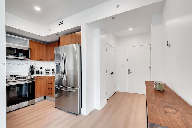 kitchen with stainless steel appliances and light hardwood / wood-style floors