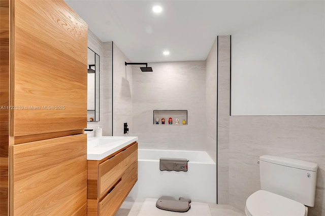 bathroom featuring vanity, tile walls, and toilet