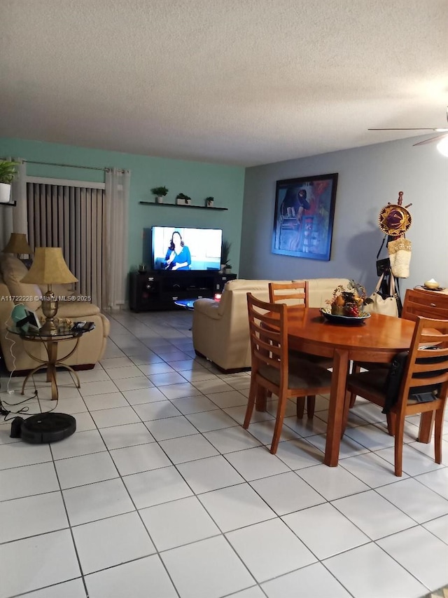 dining area featuring a textured ceiling, ceiling fan, and light tile patterned flooring