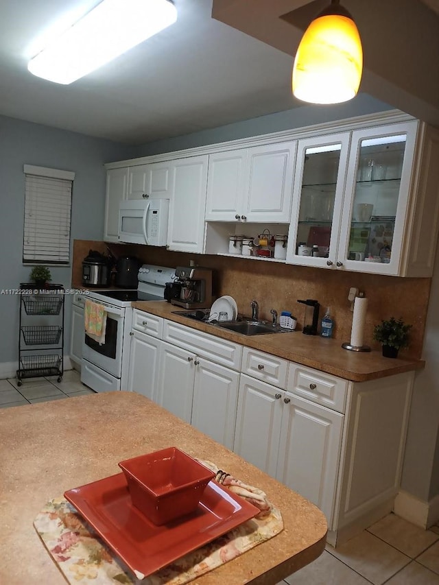 kitchen featuring sink, light tile patterned flooring, white appliances, decorative backsplash, and white cabinets