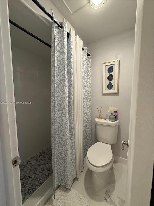 bathroom featuring walk in shower and toilet