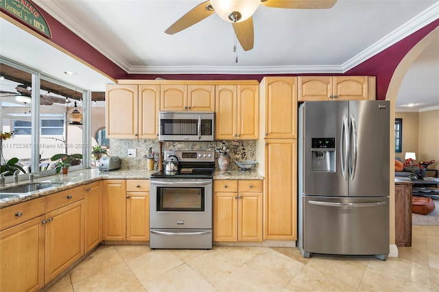 kitchen with light stone countertops, stainless steel appliances, crown molding, and sink