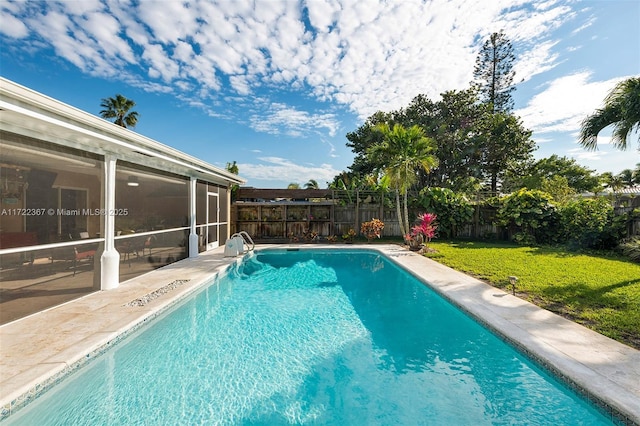 view of pool featuring a lawn and a sunroom