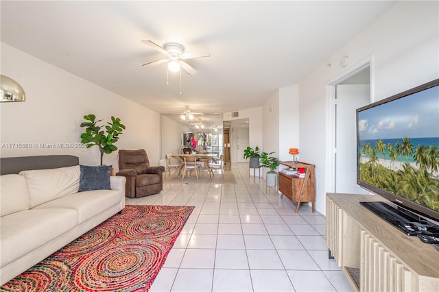 living area featuring light tile patterned floors, visible vents, and ceiling fan