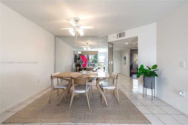 dining room with light tile patterned floors, visible vents, baseboards, and a ceiling fan