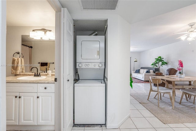 washroom with visible vents, laundry area, light tile patterned flooring, a sink, and stacked washer and dryer