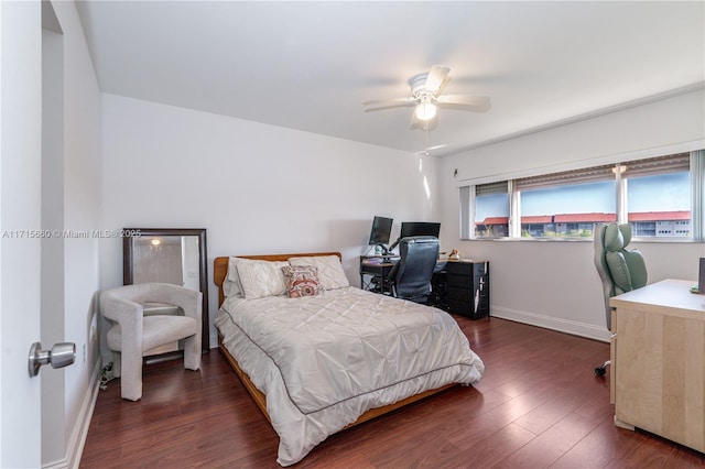 bedroom with dark wood-style floors, a ceiling fan, and baseboards