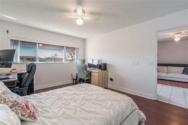 bedroom featuring ceiling fan, baseboards, and wood finished floors