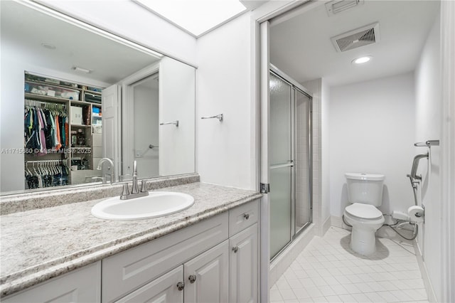 bathroom with vanity, toilet, visible vents, and a stall shower