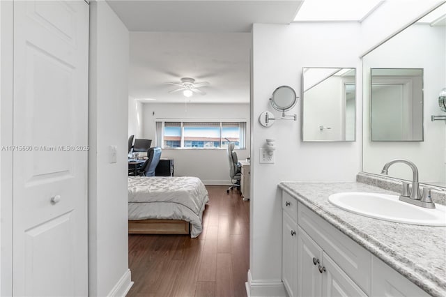 bathroom with wood-type flooring, vanity, and ceiling fan