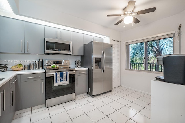 kitchen with gray cabinets, appliances with stainless steel finishes, light countertops, and a ceiling fan