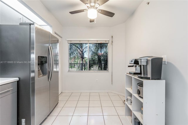 kitchen featuring baseboards, stainless steel fridge with ice dispenser, light countertops, light tile patterned floors, and a ceiling fan