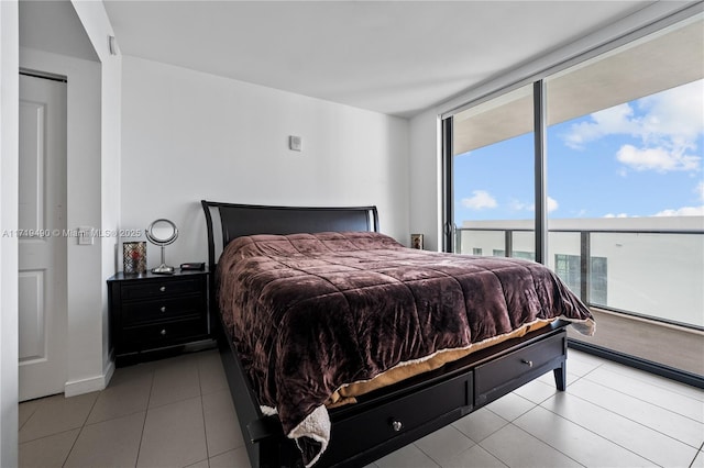 bedroom with floor to ceiling windows and light tile patterned floors