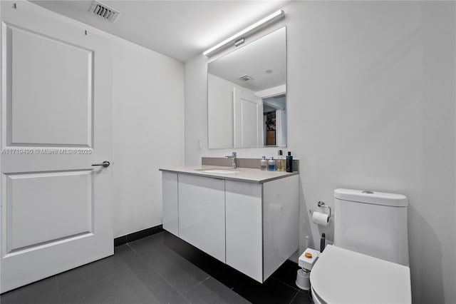 bathroom featuring tile patterned flooring, vanity, and toilet