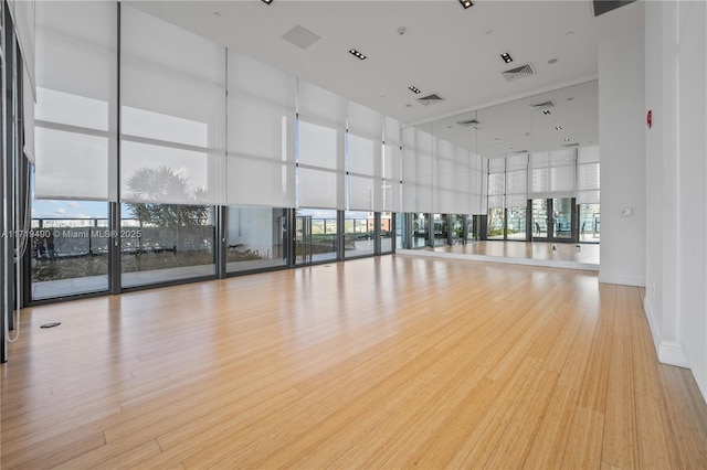 interior space featuring plenty of natural light, light hardwood / wood-style flooring, and a wall of windows