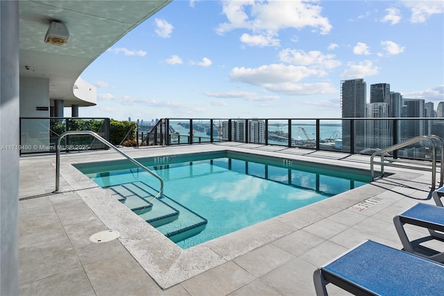 view of pool featuring a water view and a patio