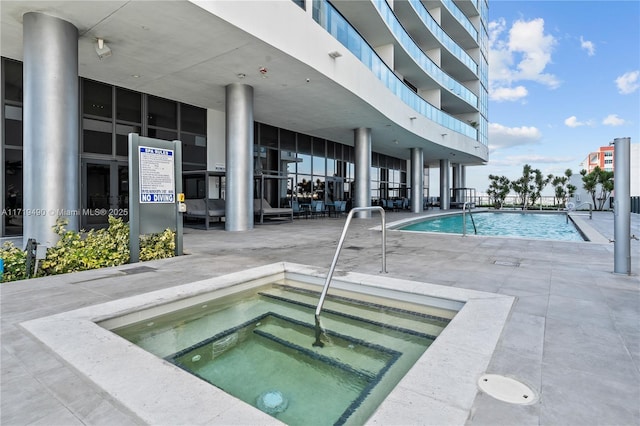 view of pool with a patio area and a hot tub