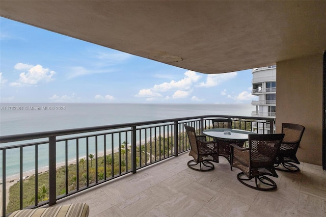 balcony featuring a water view and a beach view