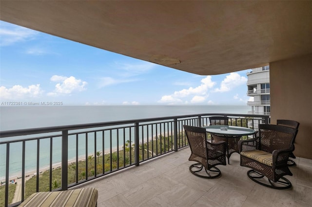 balcony with a beach view and a water view