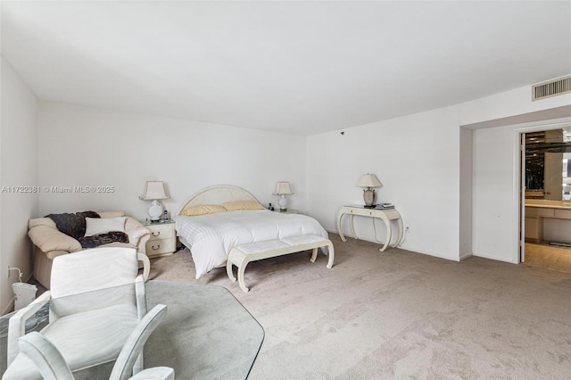 carpeted bedroom with ensuite bath