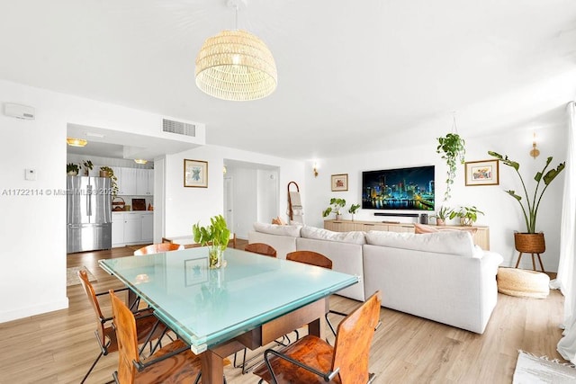 dining space with light hardwood / wood-style floors