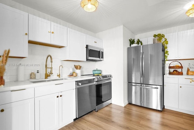 kitchen with white cabinets, appliances with stainless steel finishes, backsplash, and sink