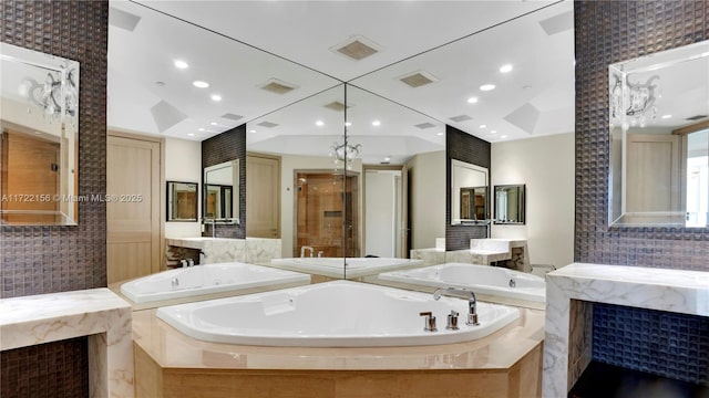 bathroom with vanity and tiled bath