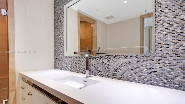 bathroom with decorative backsplash and vanity