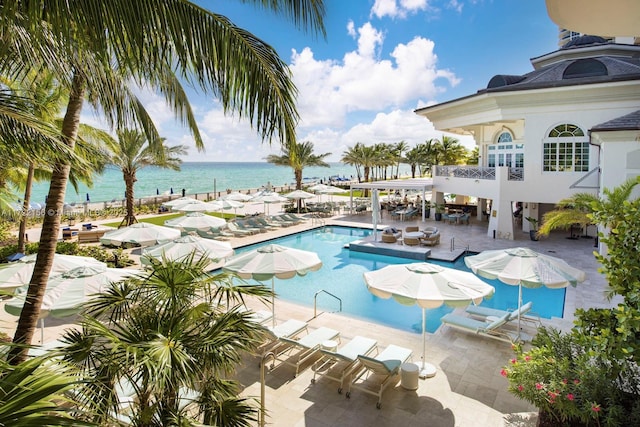 view of swimming pool with a patio and a water view