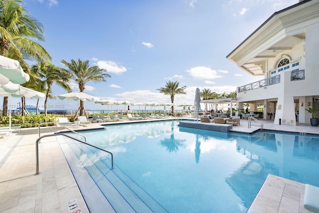 view of swimming pool with a water view and a patio