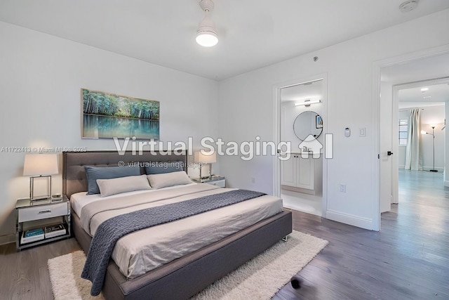 bedroom with dark wood-type flooring and connected bathroom