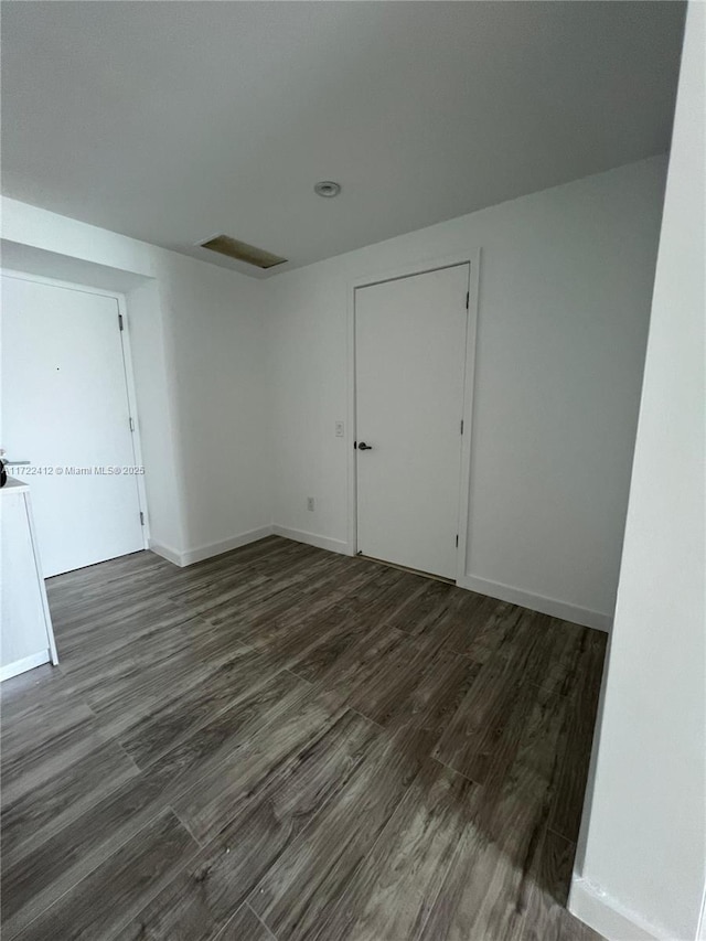 unfurnished room with dark hardwood / wood-style flooring